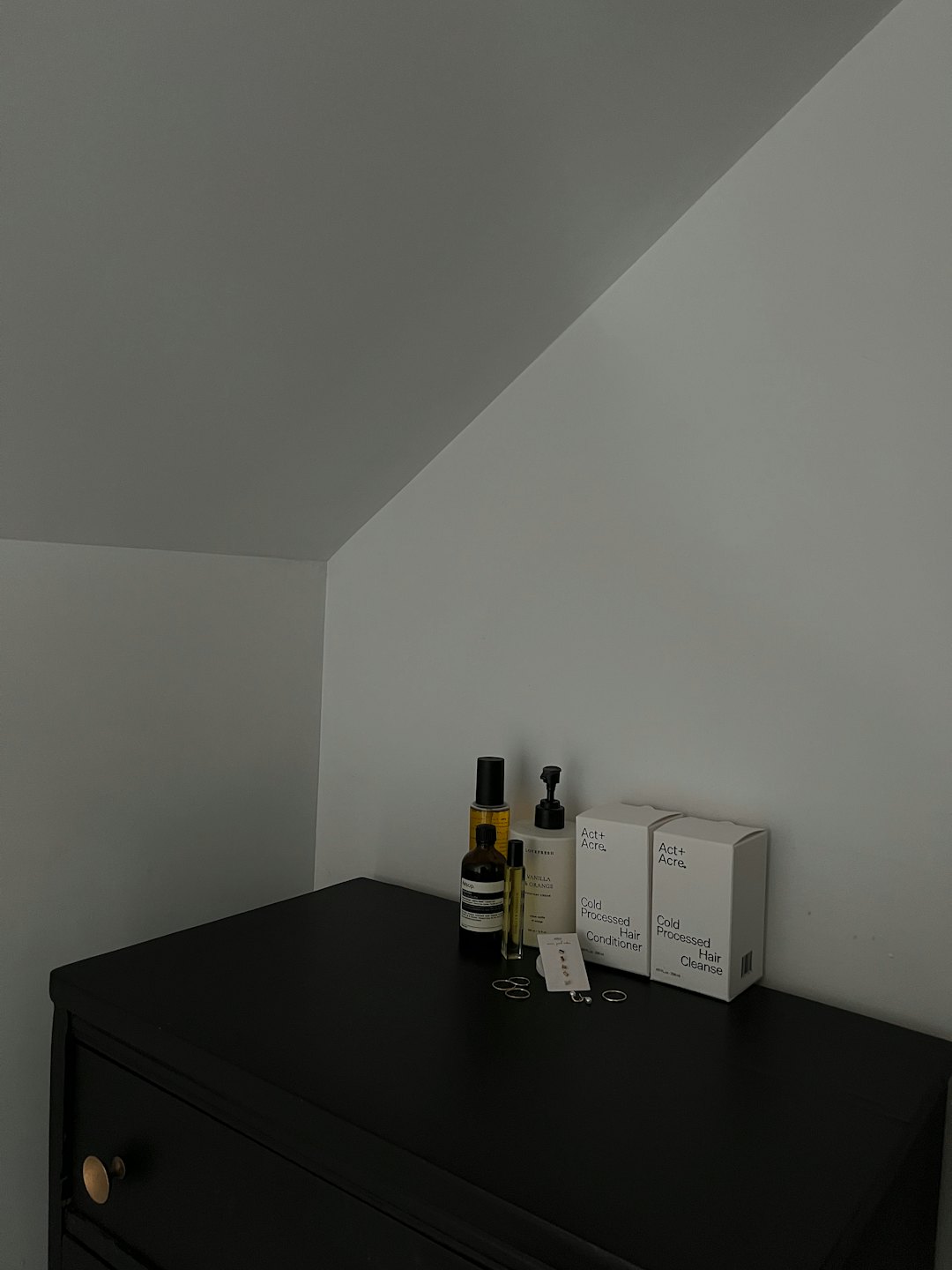 Personal care products arranged on a dark wooden dresser.